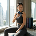 Person using a mini travel percussion massage gun